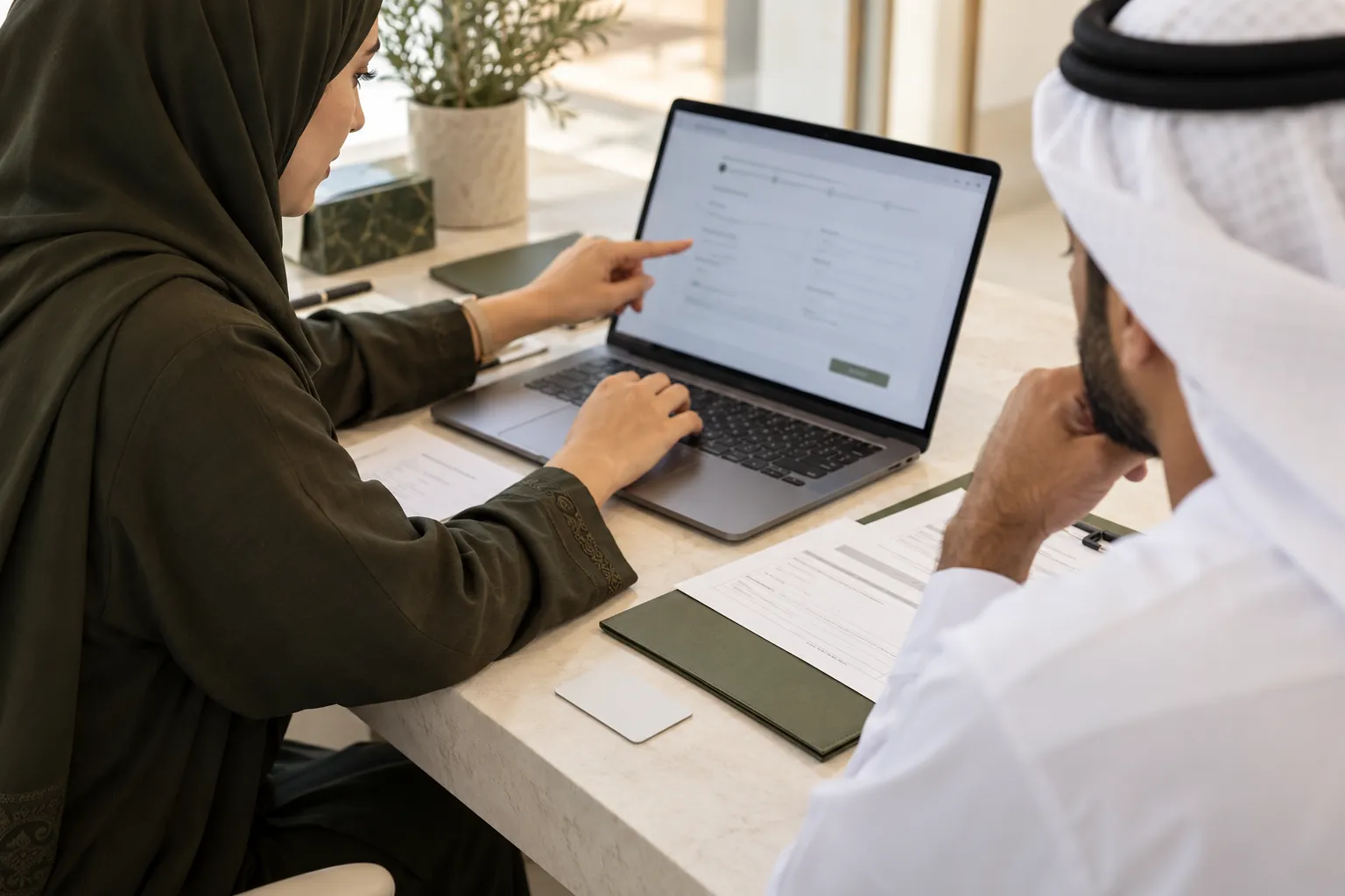Consultant helping a customer complete an identity application on a laptop.